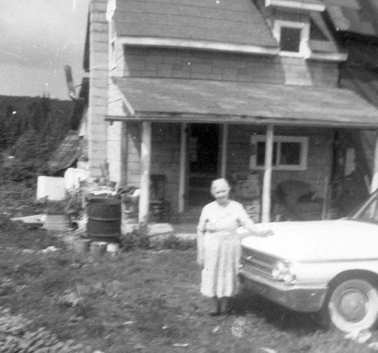 Coghlan Homestead on McKenzie Lake with Mary Catherine Ward Coghlan standing by car. Image